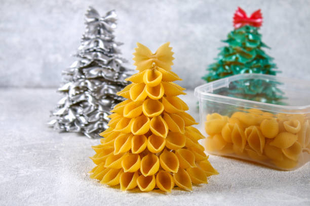 istock How to make a Christmas tree from raw pasta conchiglie. The process of making Christmas trees from pasta, cardboard plates, hot glue and paint or spray. Guide, step by step on the photo.Handmade, DIY. 1069470946