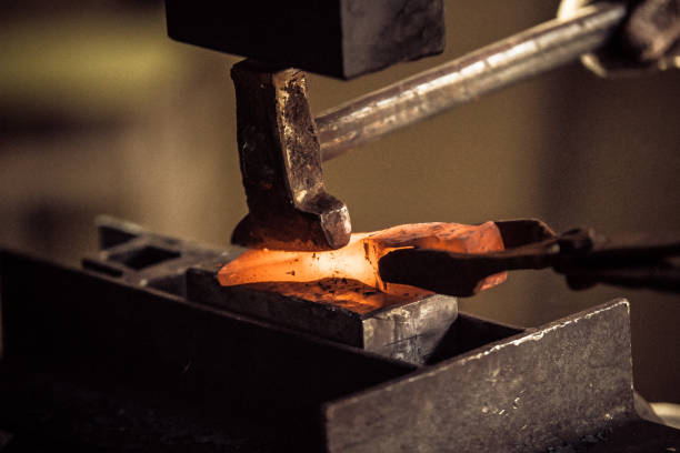 istock Blacksmith working with red hot metal workpiece of new axe on the anvil at the forge 1069470988