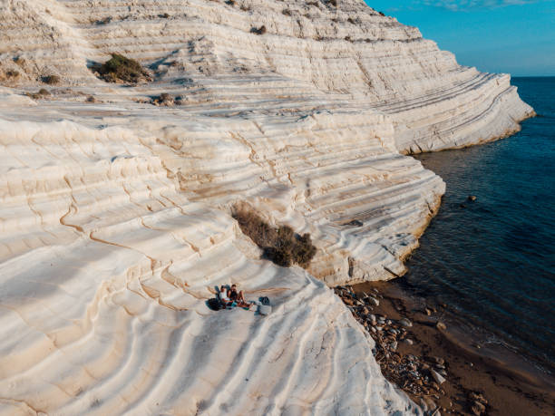 couple resting on scala dei turchi cliffs - white cliffs imagens e fotografias de stock
