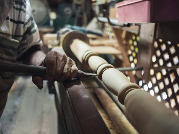 istock Hands of carpenter turning wood on lathe 1069476046