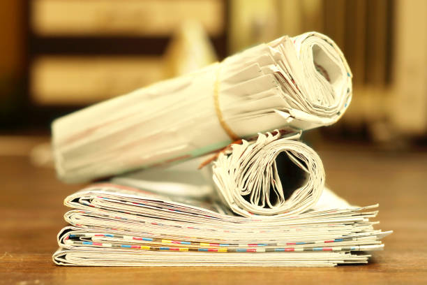istock Rolled and folded newspapers on wooden table 1069476218