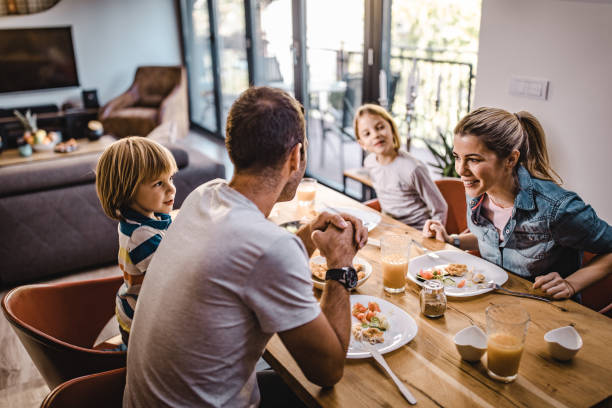istock Happy family communicating while having lunch in dining room. 1069477194