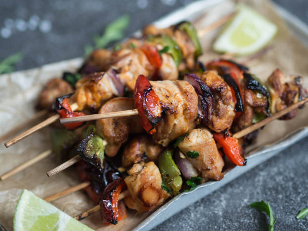 Barbecue of chicken on skewers with vegetables in metal tray