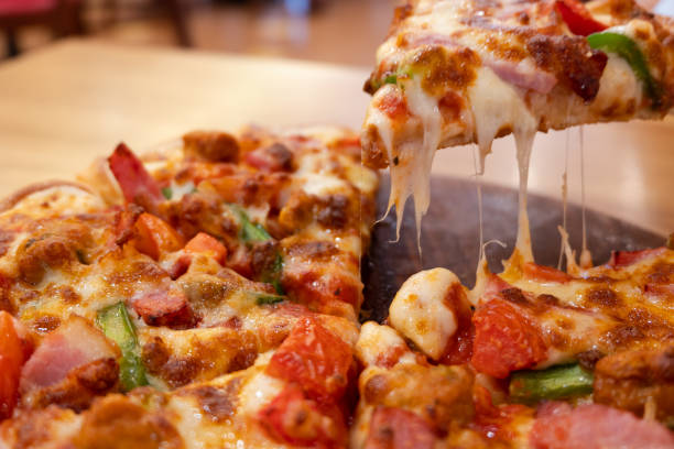 istock Close up slice of hot pizza deluxe with melting cheese. 1069478912
