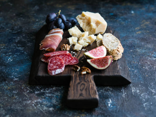 istock Dark board with various meat, cheese, grapes, bread and figs on a dark background 1069479054