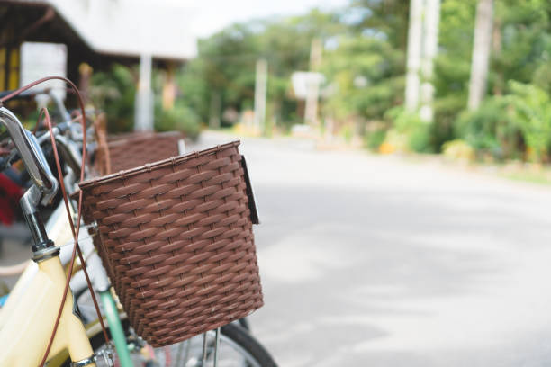 istock Yellow vintage bicycle with wicker basket on roadside with copy space. 1069481320