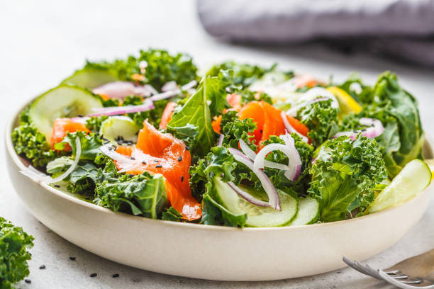 istock Salted salmon (trout) and Kale salad in a white plate on a white background. 1069481386