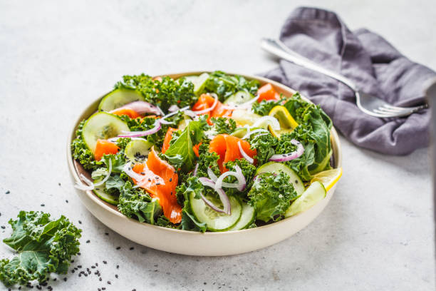 istock Salted salmon (trout) and Kale salad in a white plate on a white background. 1069481470