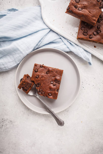 istock Piece of chocolate vegan cake with chocolate drops and nuts, top view. 1069482420