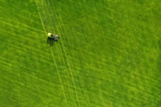 Photo of Aerial view of a ride on mower on a green field
