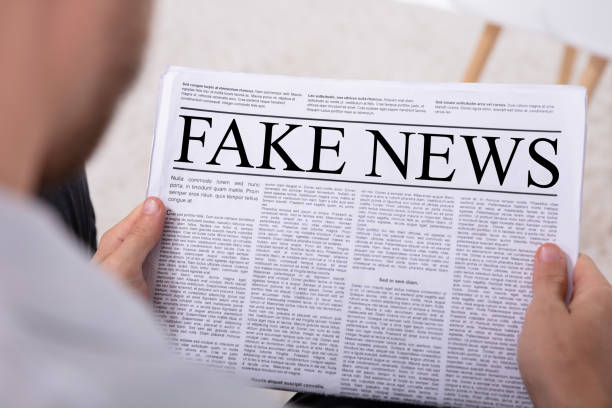 istock Man Holding Newspaper With Fake News 1069502920