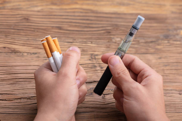 istock Close-up Of A Man's Hand Holding Vape And Cigarette 1069503846