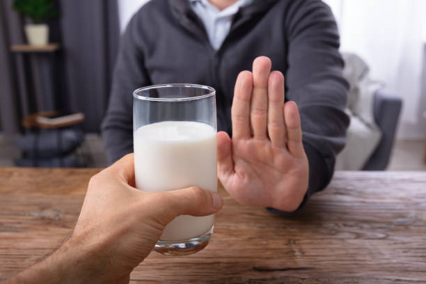 istock Man Refusing Glass Of Milk Offered By Person 1069503982