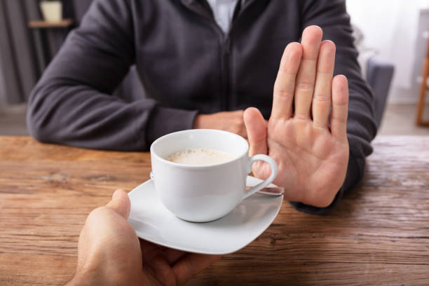 istock Man Refusing Cup Of Coffee Offered By Person 1069503988