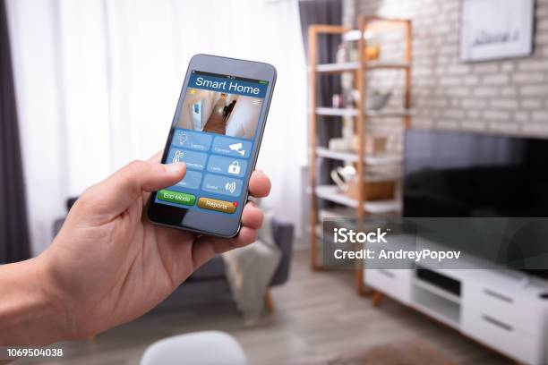 Man Holding Cellphone With Smart Home Application Stock Photo - Download Image Now - Home Automation, Security, Technology