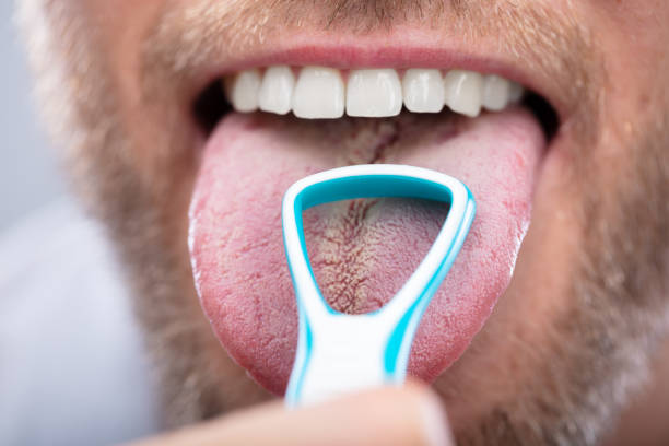 Man Cleaning His Tongue Close-up Of A Man Cleaning His Tongue With Cleaner scraping stock pictures, royalty-free photos & images