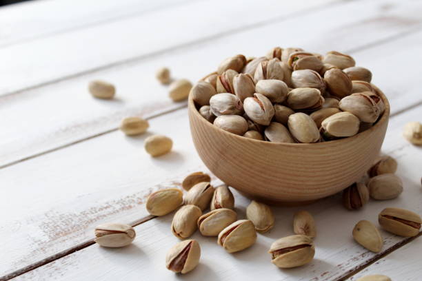istock Pistachios nuts on wooden background. 1069512374