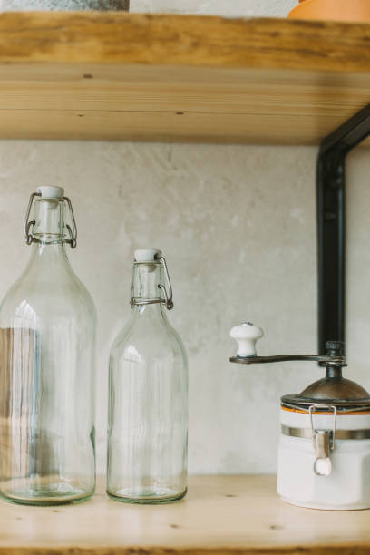 istock Kitchen shelf decoration with empty glass bottles and coffee grinder 1069514232