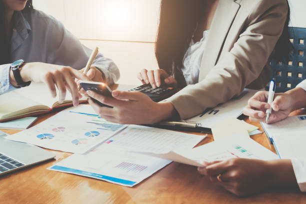 istock Business People Meeting using laptop computer,calculator,notebook,phone ,stock market chart paper for analysis Plans to improve quality next month. Conference Discussion Corporate Concept 1069516362