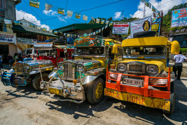 Banaue Jeepneys Station, Philippines Banaue, Philippines - April 26, 2017:   view showing Banaue jeepneys in the station, tricycles, banners, houses and people can be seen on the background philippines tricycle stock pictures, royalty-free photos & images