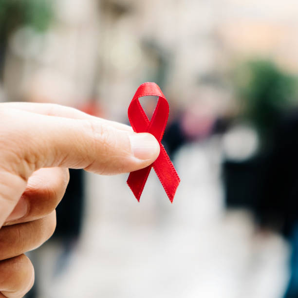 istock man with a red ribbon for the fight against AIDS 1069532152