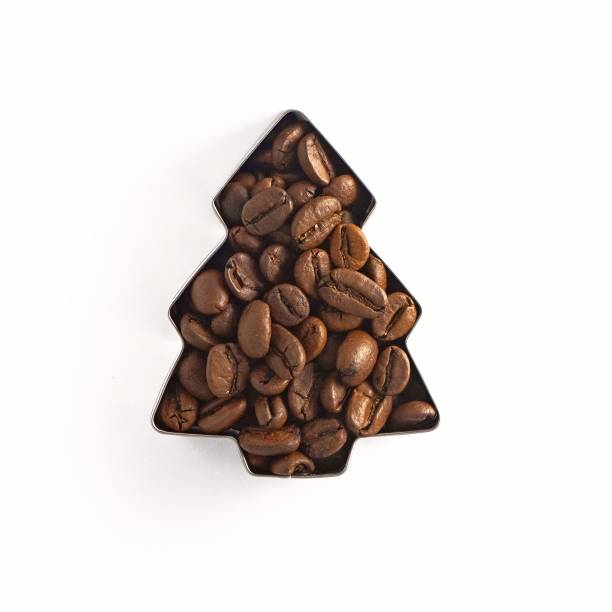 Coffee beans in the shape of a Christmas tree isolated on white background. Top view stock photo