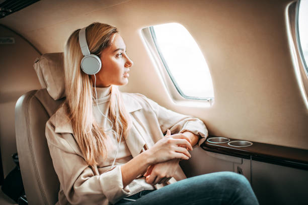 jeune femme assise dans un avion privé - status symbol audio photos et images de collection