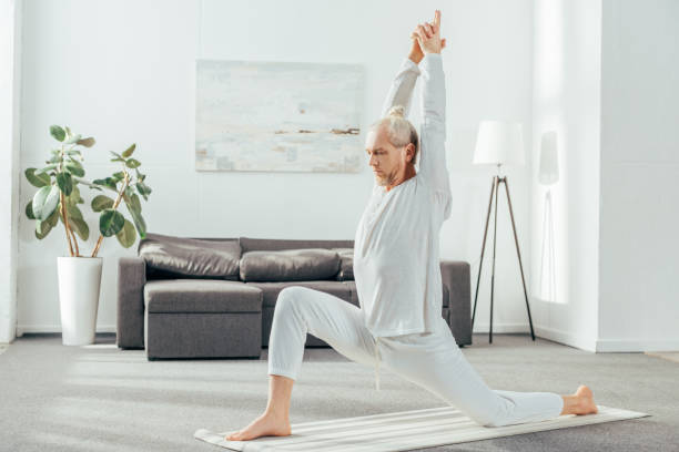 istock side view of man practicing Crescent Lunge on the Knee yoga pose at home 1069541786