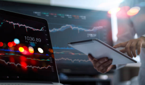 Businessman using tablet and laptop for analyzing data stock market in monitoring room background, forex trading graph, stock exchange trading online, financial investment concept. All on laptop screen are designed up. empresario con tablet y portátil para el análisis de mercado de valores de datos en el seguimiento de fondo de la habitación, gráfico de trading de forex, bolsa de comercio en línea, concepto de inversión financiera. todos en la pantalla del ordenado