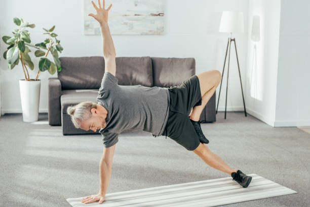 istock high angle view view of athletic man in sportswear practicing side plank on yoga mat at home 1069543700