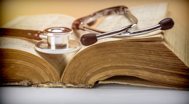 stethoscope on an old book of medicine, conceptual image - decades imagens e fotografias de stock
