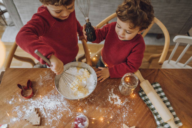 niños cocinar galletas de navidad - christmas child cookie table fotografías e imágenes de stock