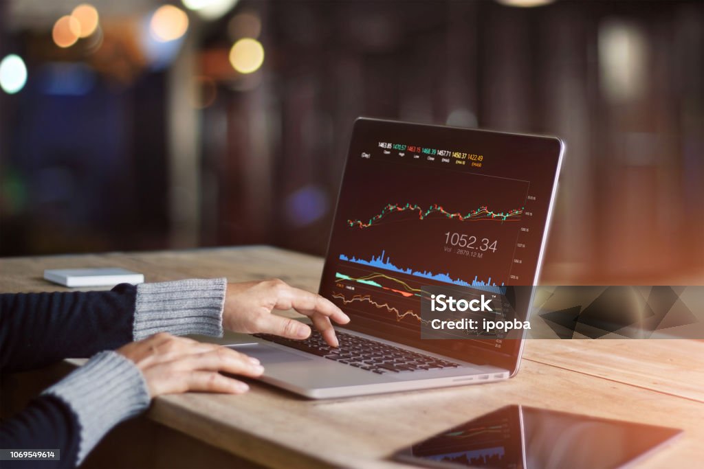 Businessman using laptop for analyzing data stock market, forex trading graph, stock exchange trading online, financial investment concept. All on laptop screen are design up. Stock Market and Exchange Stock Photo
