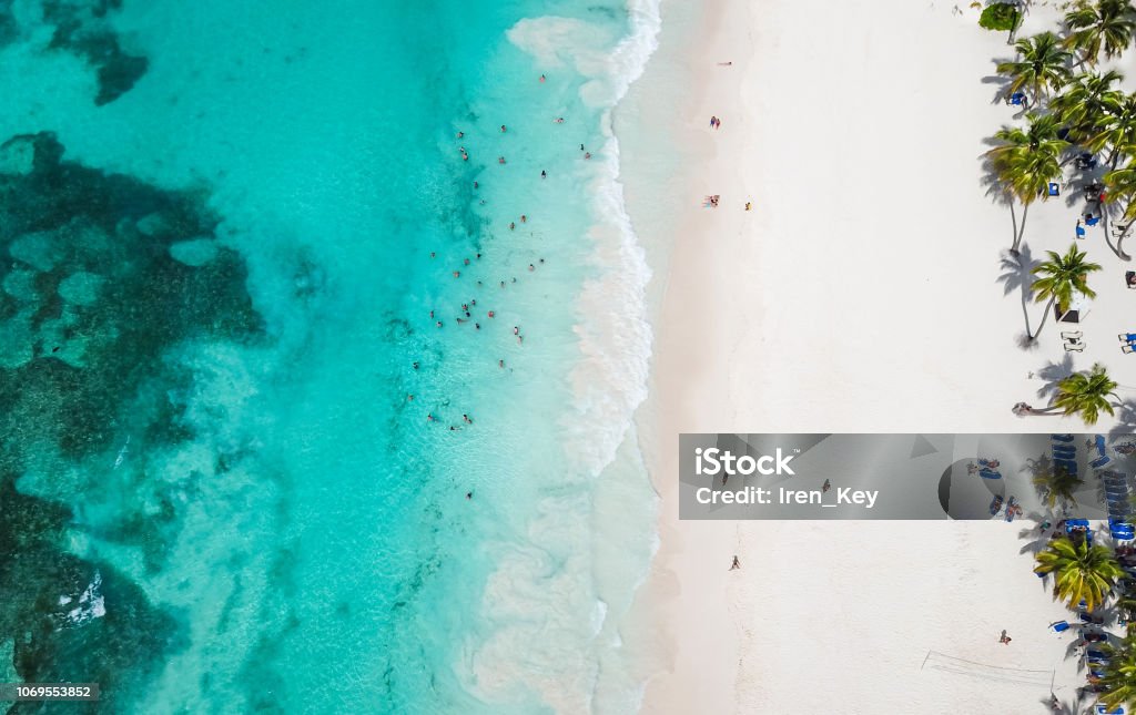 Incredible view of the white sandy beach from a bird's eye view. Top view of beautiful white sand beach with turquoise sea water and palm trees, aerial drone shot. Aerial view Beach Stock Photo