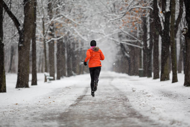 istock rear view woman jogging alone through alley on cold winters day 1069557708