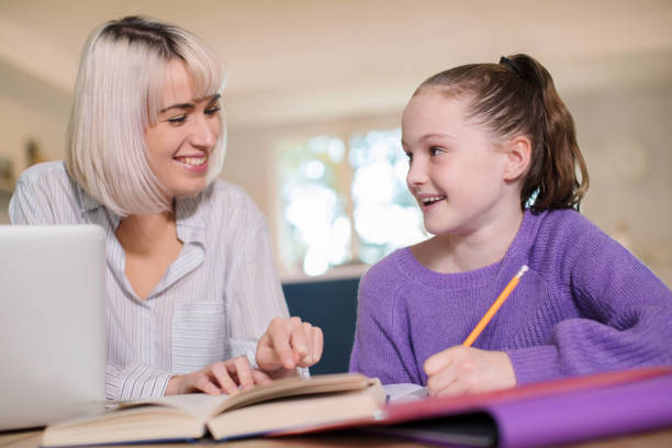 istock Female Home Tutor Helping Young Girl With Studies 1069559824