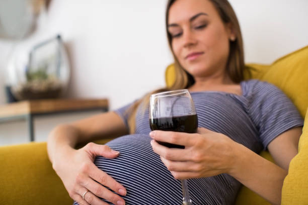 istock Concerned Pregnant Woman Drinking Red Wine At Home 1069560006