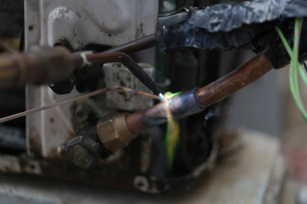 istock Technician are soldering a coil with copper in order to fix leakage of air compressor. This is a oil and piping problem of air-conditioner unit. 1069561894