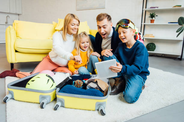 istock happy family having great time, using digital tablet and packing for winter holidays 1069561970