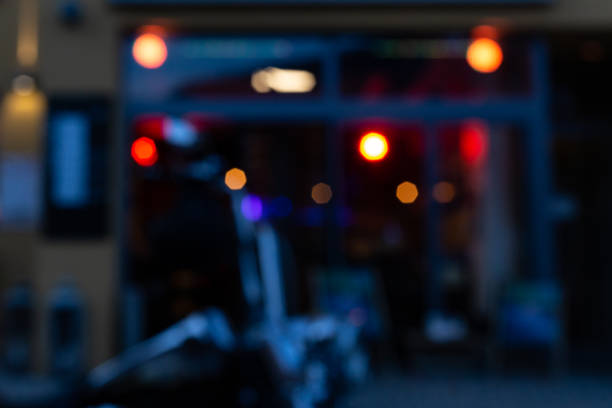 blurred bistro and pub neon lights at evening in city mall of south germany metropole with motorbike parts