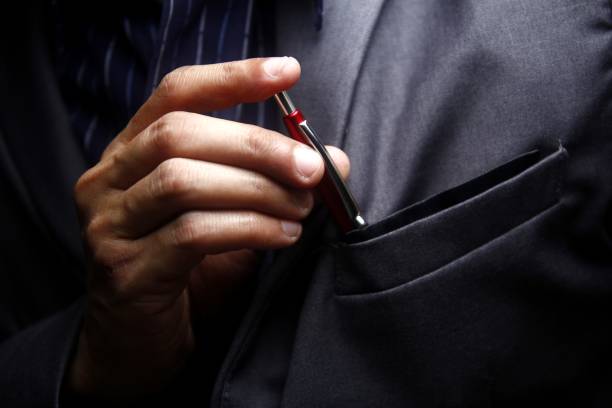 Man inserting a pen to his suit's pocket stock photo
