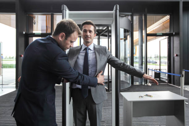 Security check businessman Security man check businessman at entrance in office building or airport metal detector security stock pictures, royalty-free photos & images