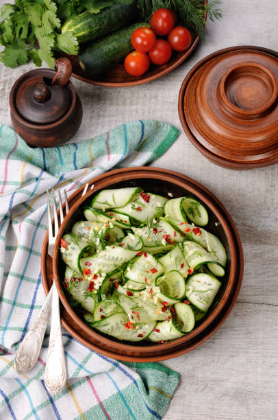 istock A bowl of salad from cucumber strips with spices, garlic and dill. Rustic style. 1069567540
