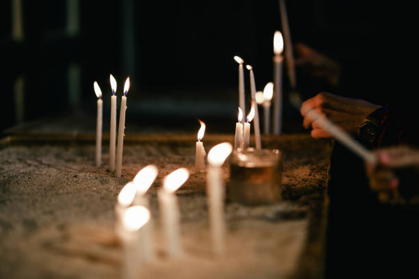 istock woman hand lighting candles in a church 1069568048