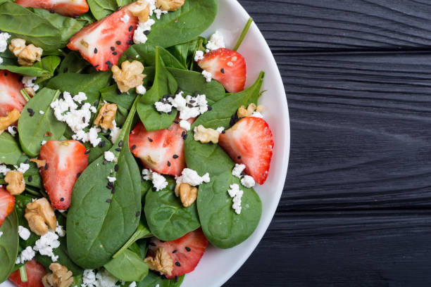istock Strawberry salad with spinach , cheese and walnut . Healthy food 1069571420