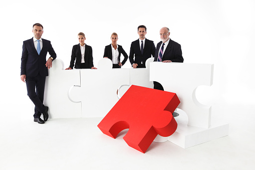 Business team portrait and big puzzle isolated on white background