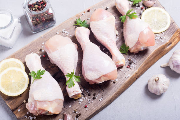 istock Raw chicken legs with spices and parsley. Food background 1069571644