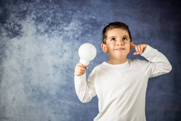 istock Little kid with a bulb light in his hands. dea concept 1069575488
