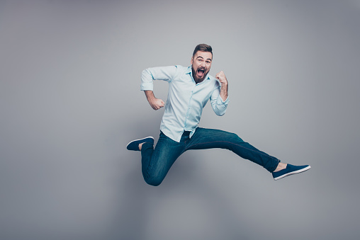 Full body size length studio photo portrait of crazy mad optimistic positive guy with open mouth looking at camera isolated gray background copy space