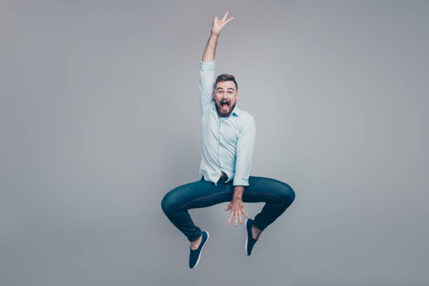 istock Full length body size studio photo portrait of childish playful handsome optimistic glad ecstatic crazy guy jumping up isolated gray background 1069578126